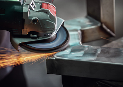 Vinkelslip som skär metall, gnistor flyger från kontaktpunkten.