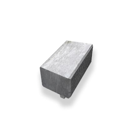 Rektangulär, ljusgrå betongsten med en slät ovansida och texturerad sida.