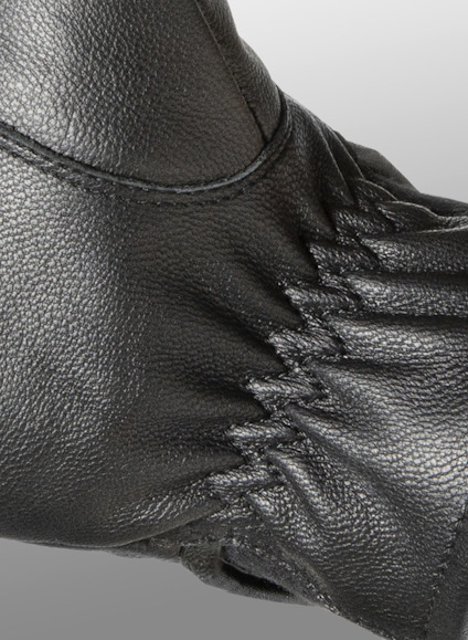 Svart skinnmaterial med elastisk rynkning och detaljsöm.