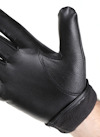Svart läderhandske på en hand, med ett handledsparti i mörkt tyg.