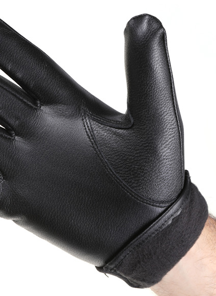 Svart läderhandske på en hand, med ett handledsparti i mörkt tyg.