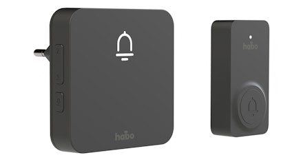 Trådlös dörrklocka i svart med tryckknapp och enheten ansluten till vägguttag, båda med logotypen "habo".