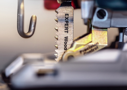 Närbild på en sågklinga märkt "EXPERT Wood" monterad på en elektrisk sticksåg.