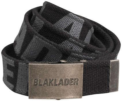 Svart textilbälte med metallspänne. Spännet har ingraverad text: "BLAKLADER". Bältet är hoprullat.