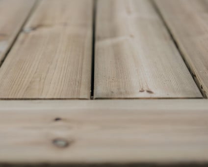 Trallbrädor lagda sida vid sida, med synlig ådring och ljus träfärg.