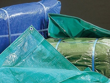 Blå, gröna och turkosa presenningar med öljetter, bundna med blå band.