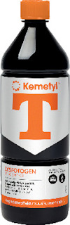Flaska med orange kork och etikett med texten "Kemetyl T LYSFOTOGEN BRÄNSLETEKNIK".