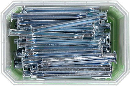 Fyrkantig grön plastbehållare fylld med silverfärgade skruvar.