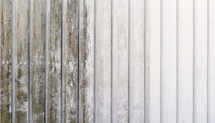 Vitmålad träpanel med både smutsig och ren yta.