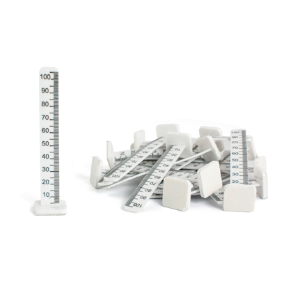 Flera vita plastnivåmarkörer med gradskalor, en står upprätt medan de andra ligger huller om buller.